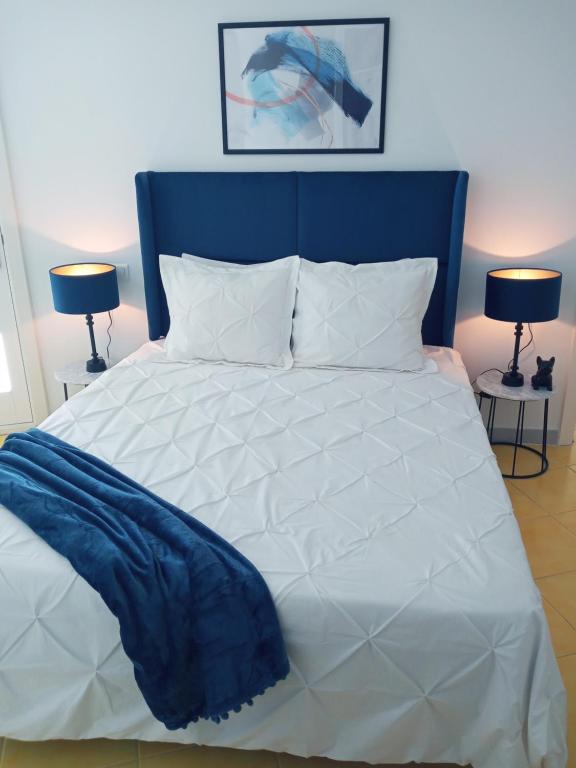 sypialnia z dużym łóżkiem z niebieskim zagłówkiem w obiekcie Skyline Suites Costa del Sol w mieście Torremolinos