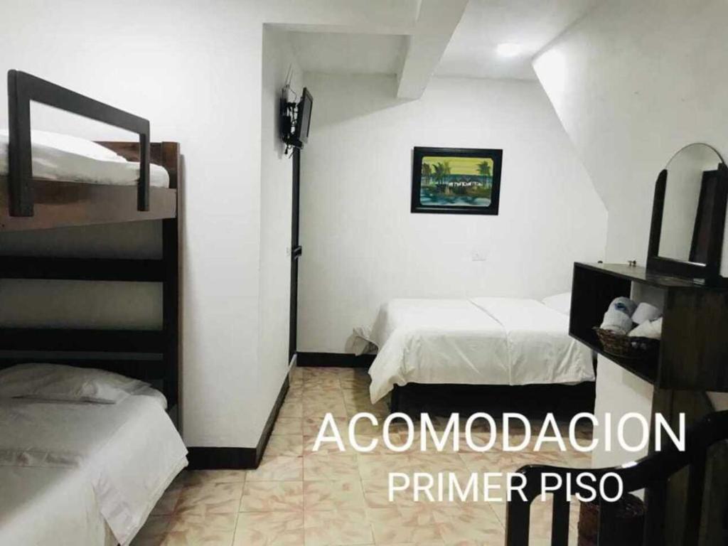 a bedroom with two beds and a television in it at Hostal Diana in San Agustín
