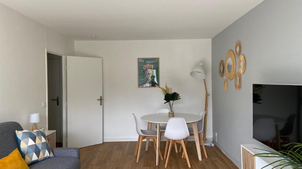 a living room with a table and chairs at LE CYLIA in Mérignac