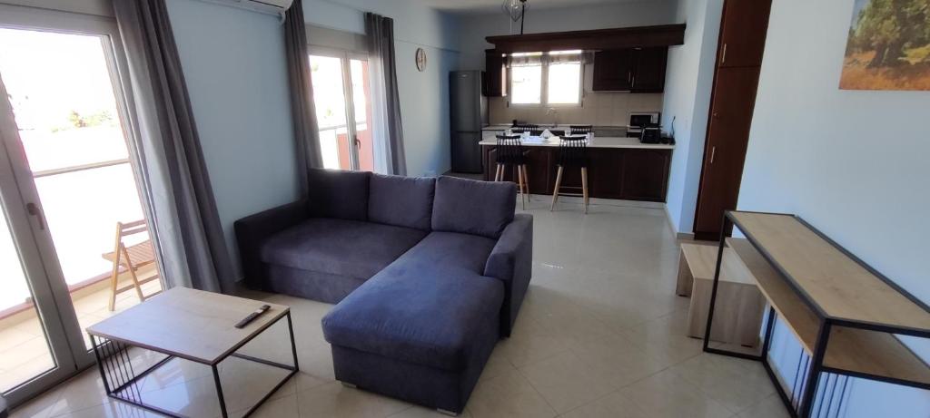 uma sala de estar com um sofá azul e uma cozinha em el greco apartment in Ilha de Rhodes
