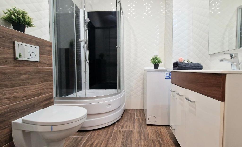 a bathroom with a shower and a toilet and a sink at Apartament Czechowska Comfort in Lublin