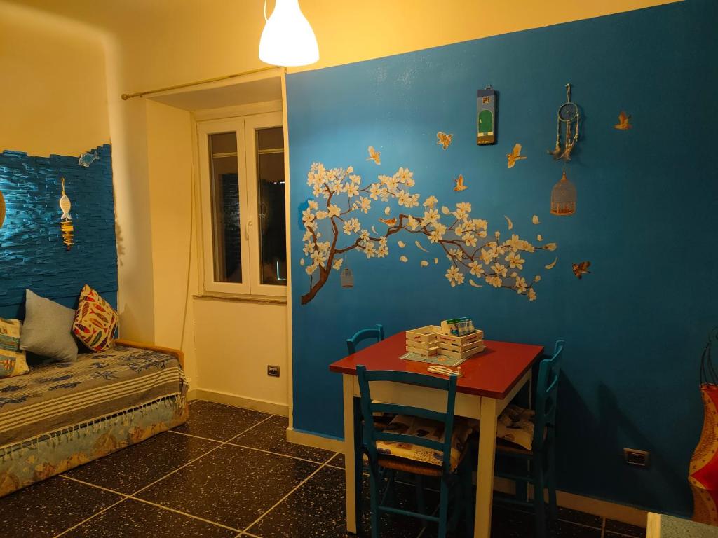 um quarto com uma parede azul com uma árvore em La casa di Zahra em Riccò del Golfo di Spezia