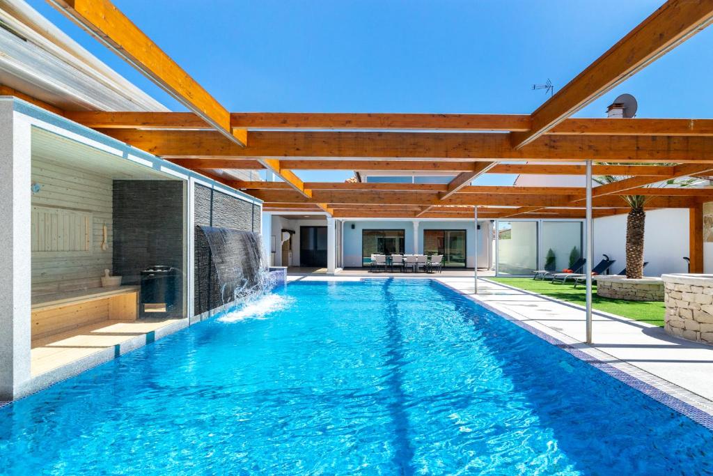 een buitenzwembad met een grote houten pergola bij WHome Hideaway Luxury Family Villa w/ S-Pool & AC in Ourém