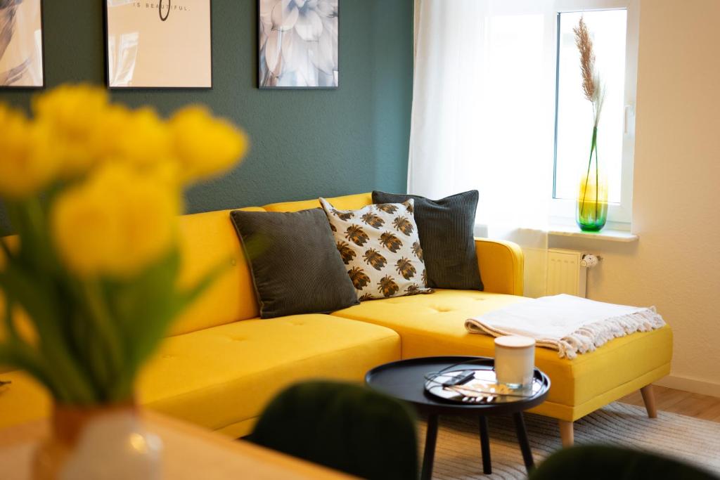 - un canapé jaune dans le salon avec une table dans l'établissement Levax Living - Cozy - Clarapark - citynah, à Leipzig
