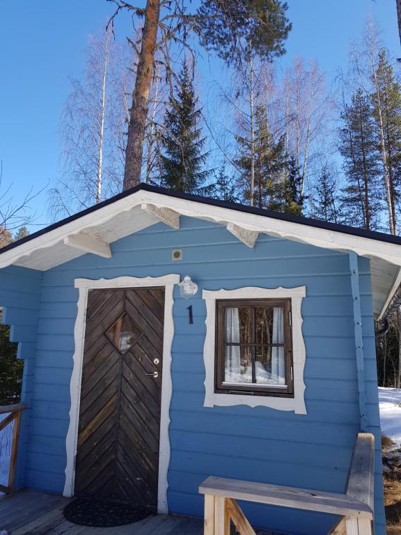 a blue shed with a door and a window at Schöne Stuga unmittelbar am Ammerån gelegen in Hammarstrand