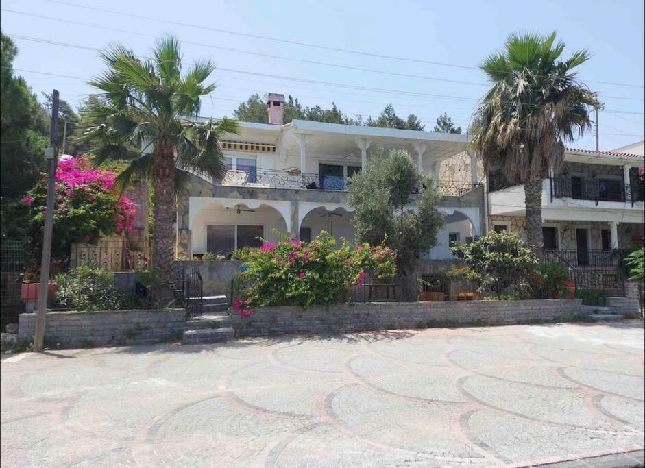 duży biały dom z palmami przed nim w obiekcie Bodrum’da Özel İskeleli 4+1 Yalı Dairesi w Bodrum