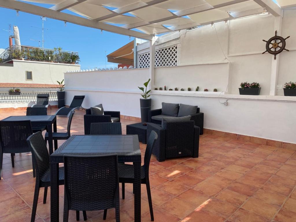 een patio met tafels en stoelen en een bar bij Maison Brancaleone in Barletta