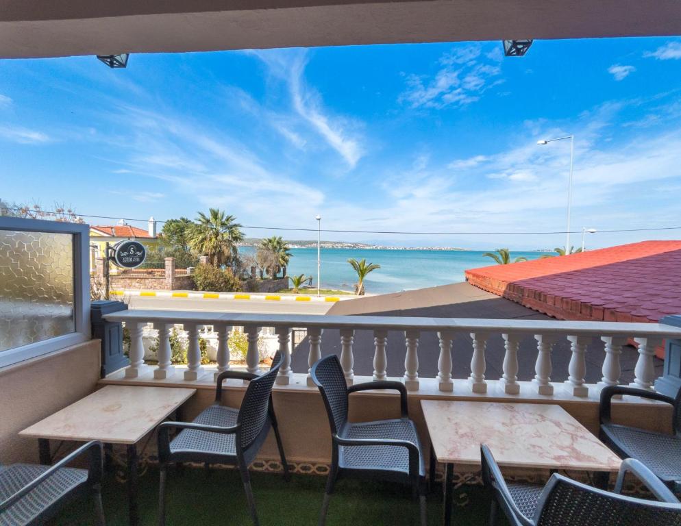 d'un balcon avec des tables et des chaises et une vue sur l'océan. dans l'établissement Sözer Otel, à Ayvalık
