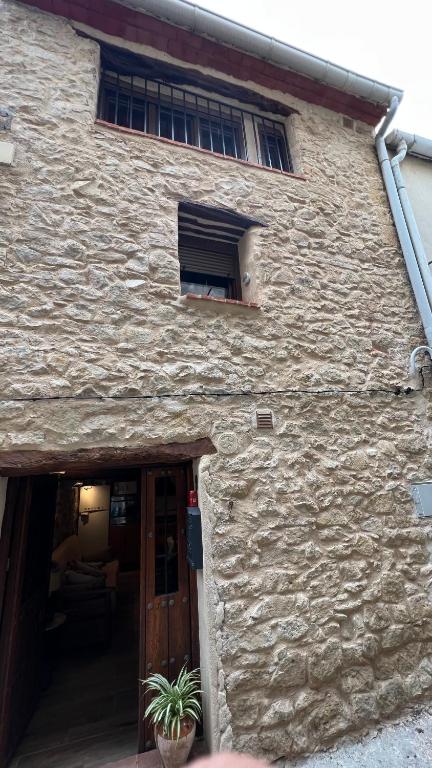a stone building with a door and a window at La gallina in Arnés
