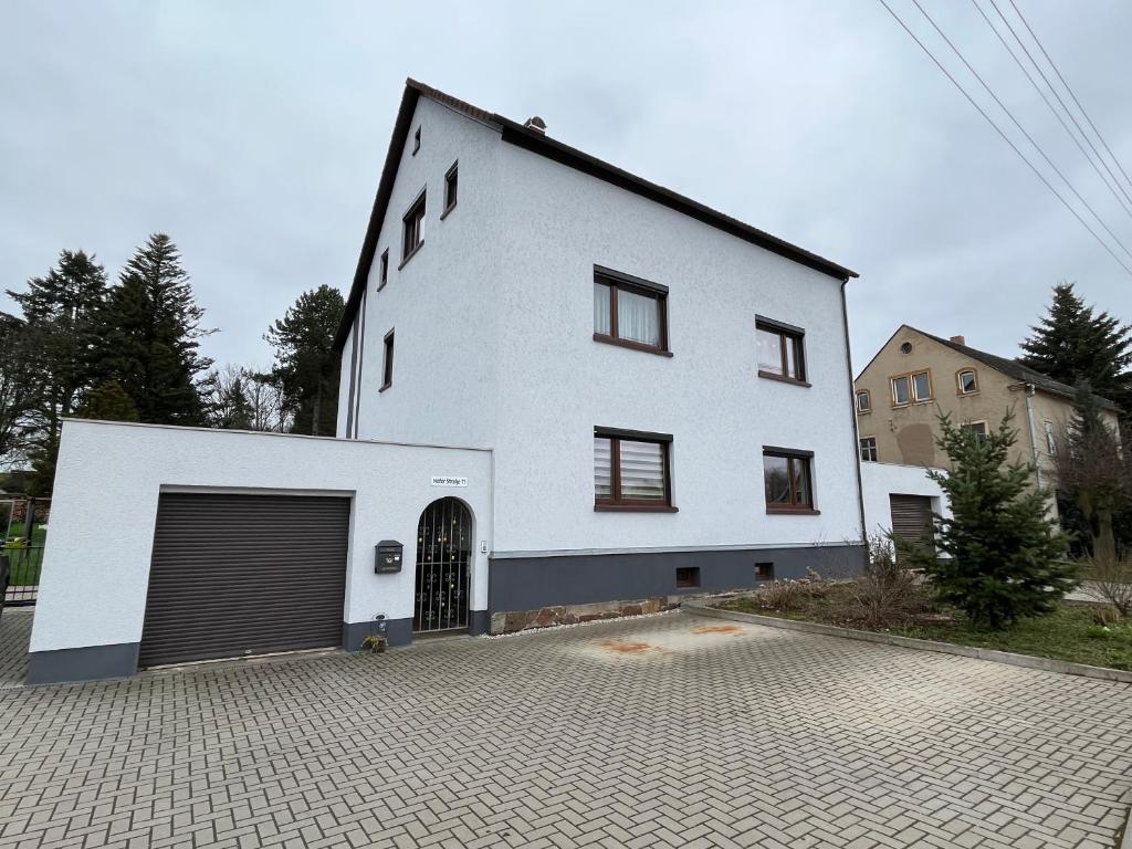 a large white house with a garage at Pension 71 in Mittelbach