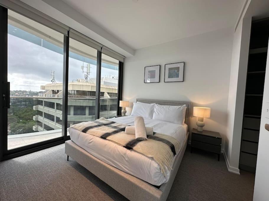 1 dormitorio con cama grande y ventana grande en City view designed apartment in Bondi Junction en Sídney