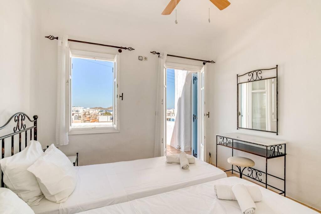 a white bedroom with two beds and a desk at Thálassa House - Walking distance to Naoussa in Naousa