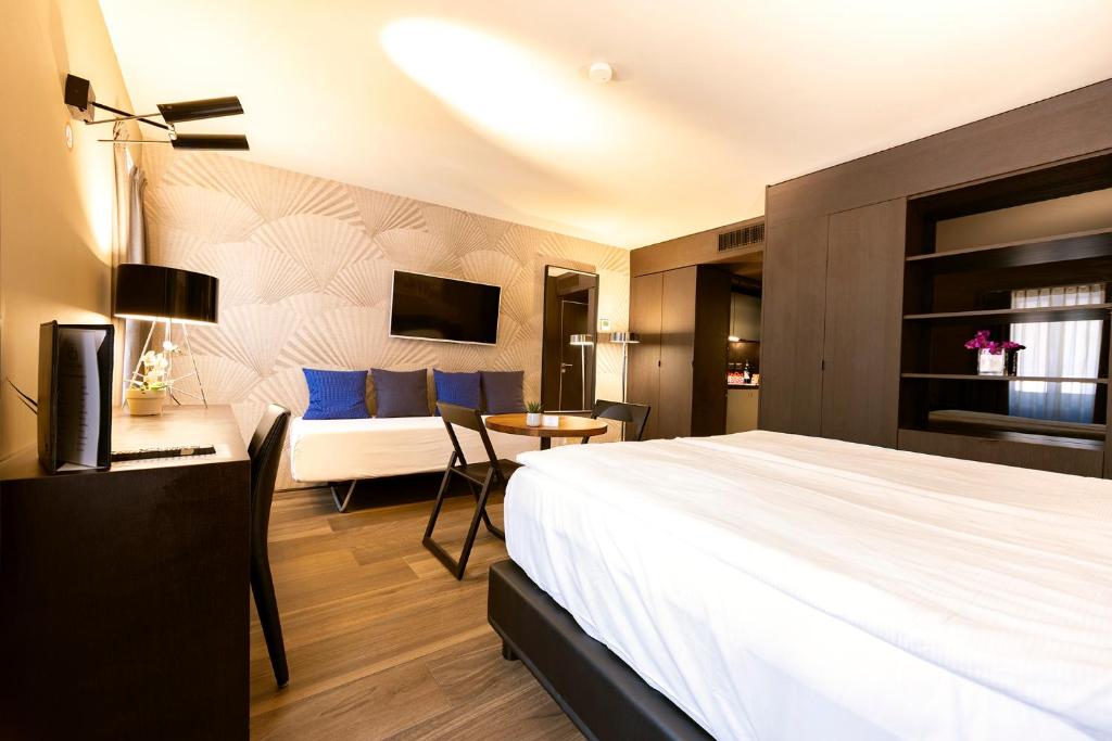 Habitación de hotel con cama y sofá en San Carlo Suite, en Lugano