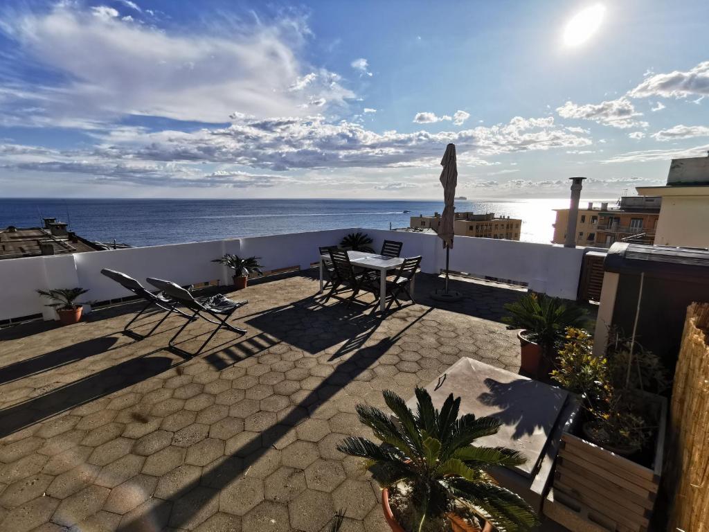 een balkon met een tafel en stoelen en de oceaan bij Blue Nest in Genua
