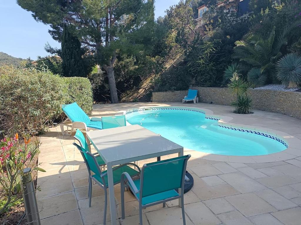 a table and chairs next to a swimming pool at LA MADRAGUE- 2P avec piscine privative in Saint-Cyr-sur-Mer