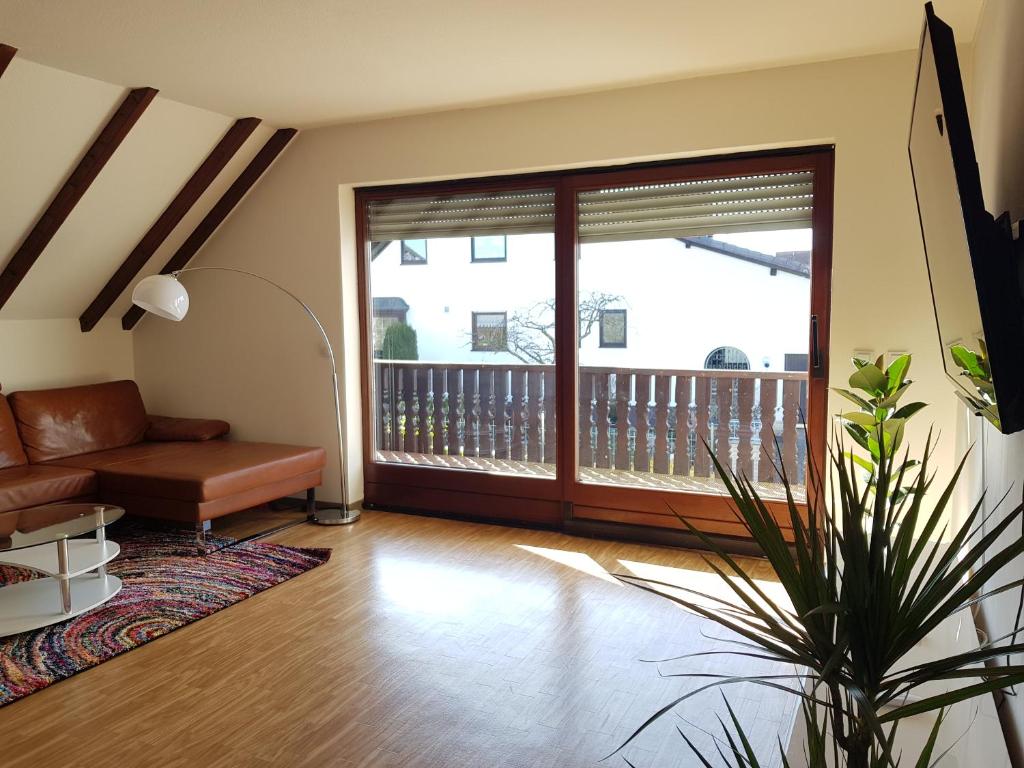 a living room with a couch and a balcony at Beautiful 3 rooms apartment 110 m2, kostenloser Parkplatz, großer Balkon in Heßdorf