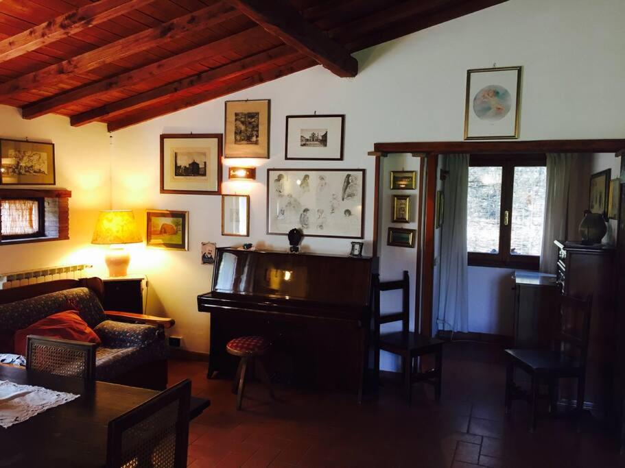 a living room with a table and a piano at Chalet La Sequoia Orte zona terme in Orte