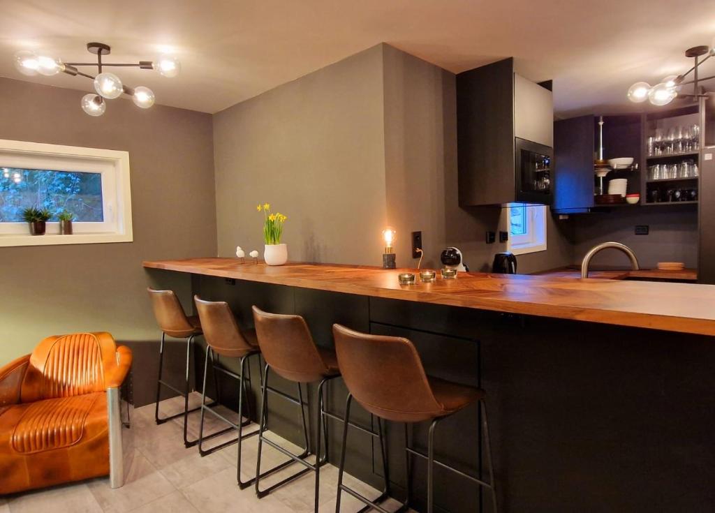 eine Küche mit einer Bar mit braunen Stühlen in der Unterkunft #26 Sokndal in Sokndal