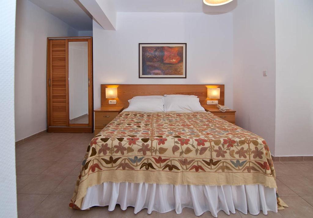 a bedroom with a large bed with a blanket at Lycia Hotel in Kaş