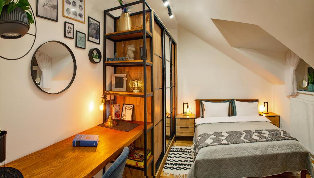 1 dormitorio con cama y escritorio con espejo en Old Town Loft Apartments, en Kamianets-Podilskyi