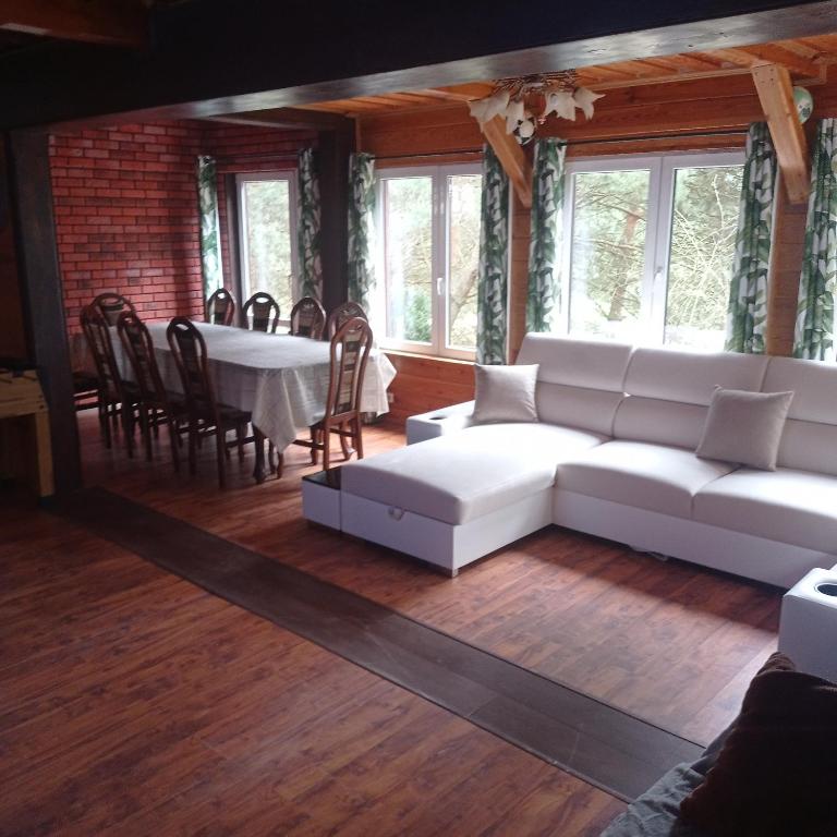 salon z białą kanapą i stołem w obiekcie Dom Parlinek agroturtstyka wędkowanie sauna jacuzzi w mieście Dąbrowa