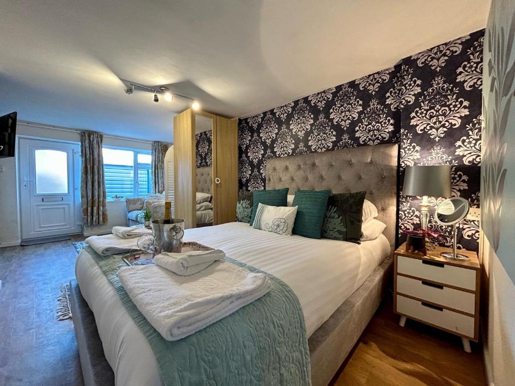 a bedroom with a large bed with a table on it at BOURNECOAST: LOVELY GROUND FLOOR STUDIO APARTMENT, NEAR RIVER & BEACHES - FM3001 in Iford