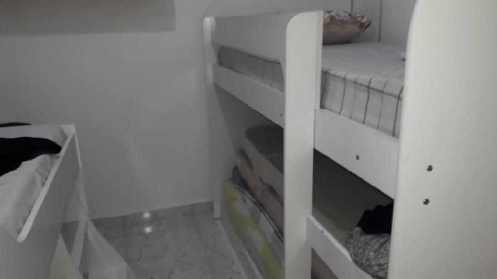 Habitación con litera blanca en una habitación en Casa das Gaivotas, en Itanhaém