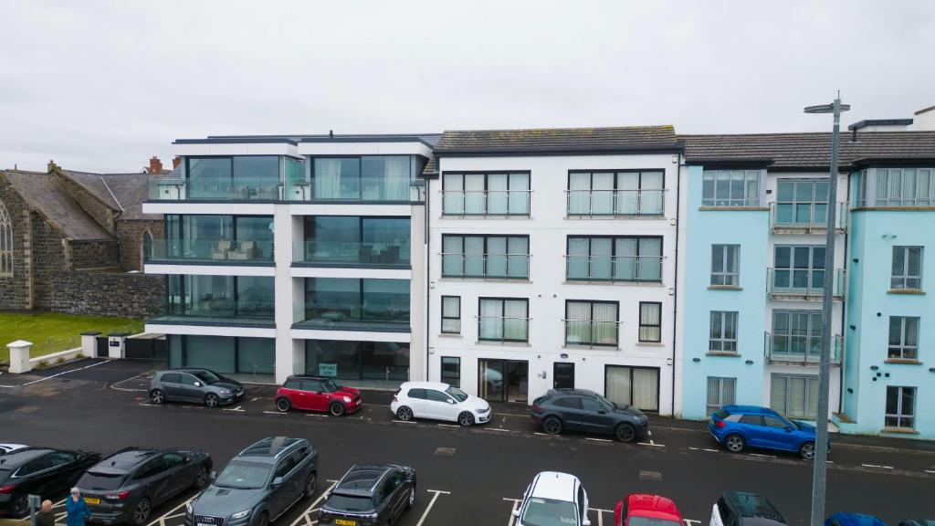 a parking lot with cars parked in front of a building at 1 Island View in Portrush