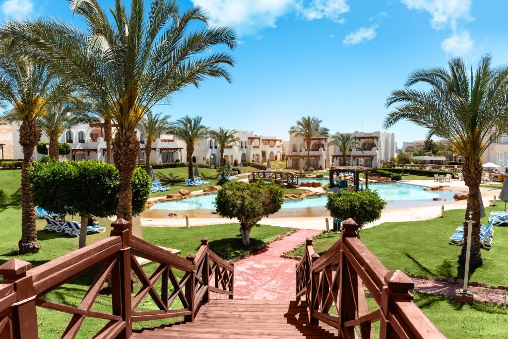 un complexe avec une piscine et des palmiers dans l'établissement Sharm Dreams Vacation Club - Aqua Park, à Charm el-Cheikh