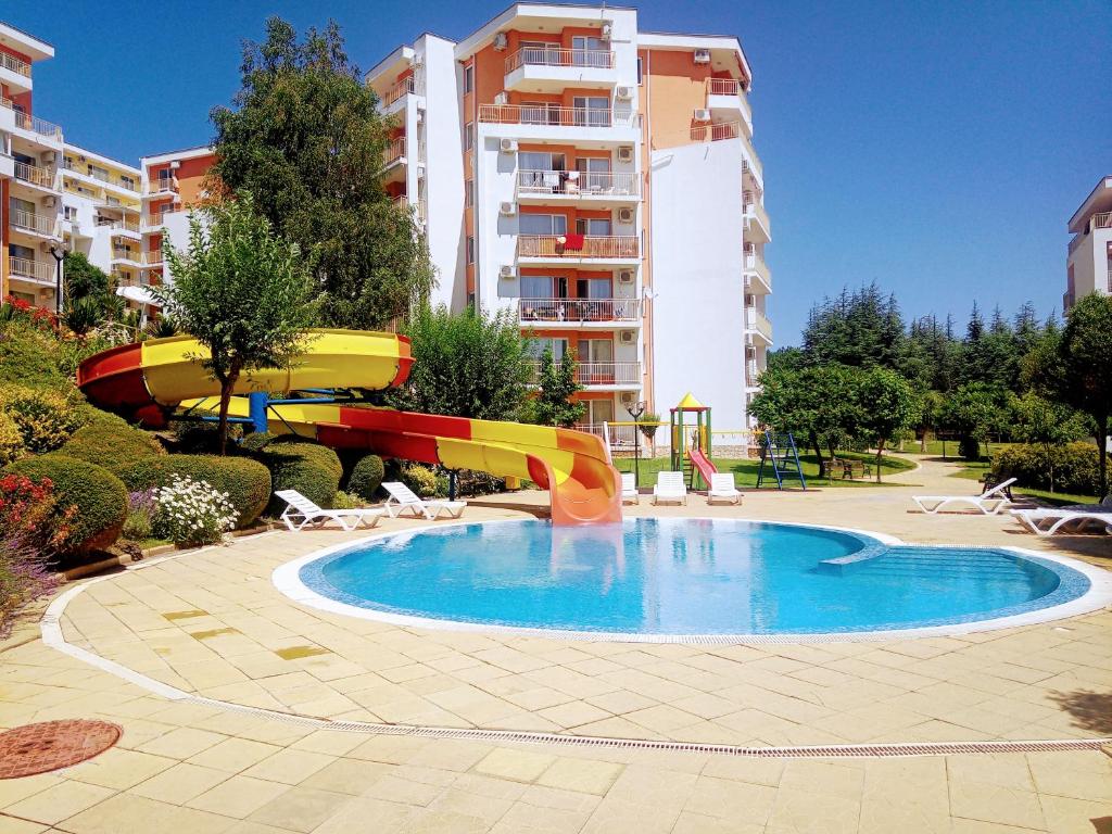 a swimming pool with a slide in a building at Family Apartament Crown Pool&Sea - BastetBS in Sveti Vlas