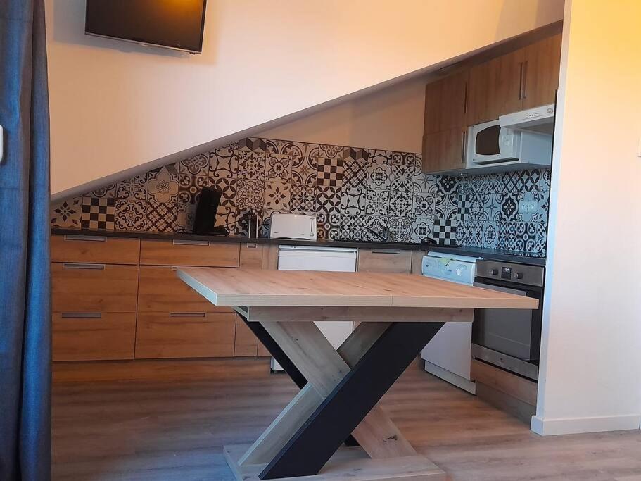 kuchnia z drewnianym stołem z blatem w obiekcie Location appartement à Bonascre w mieście Ax-les-Thermes