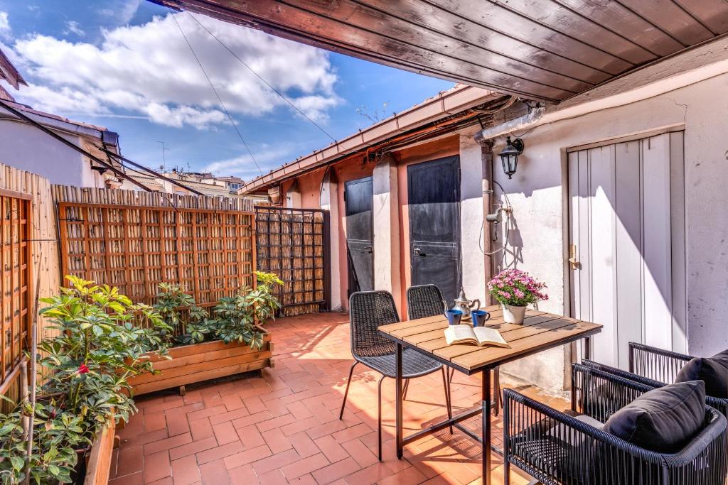 un patio al aire libre con mesa de madera y sillas en RR Apartments San Giovanni, en Roma