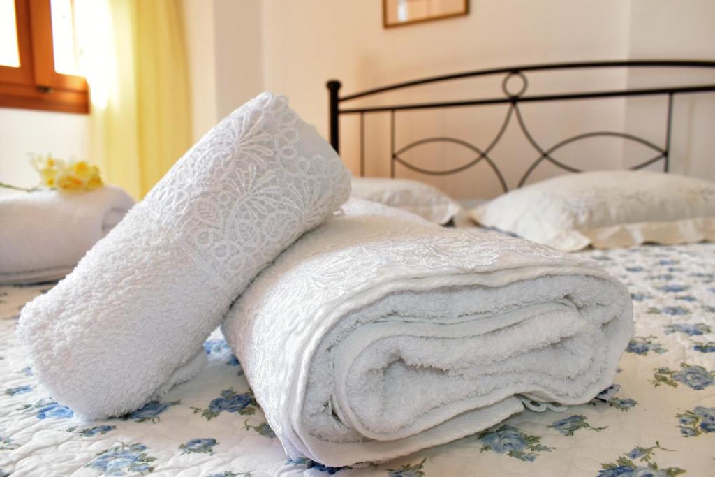 a pile of white towels sitting on top of a bed at Siel Oneiro House in Ermoupoli