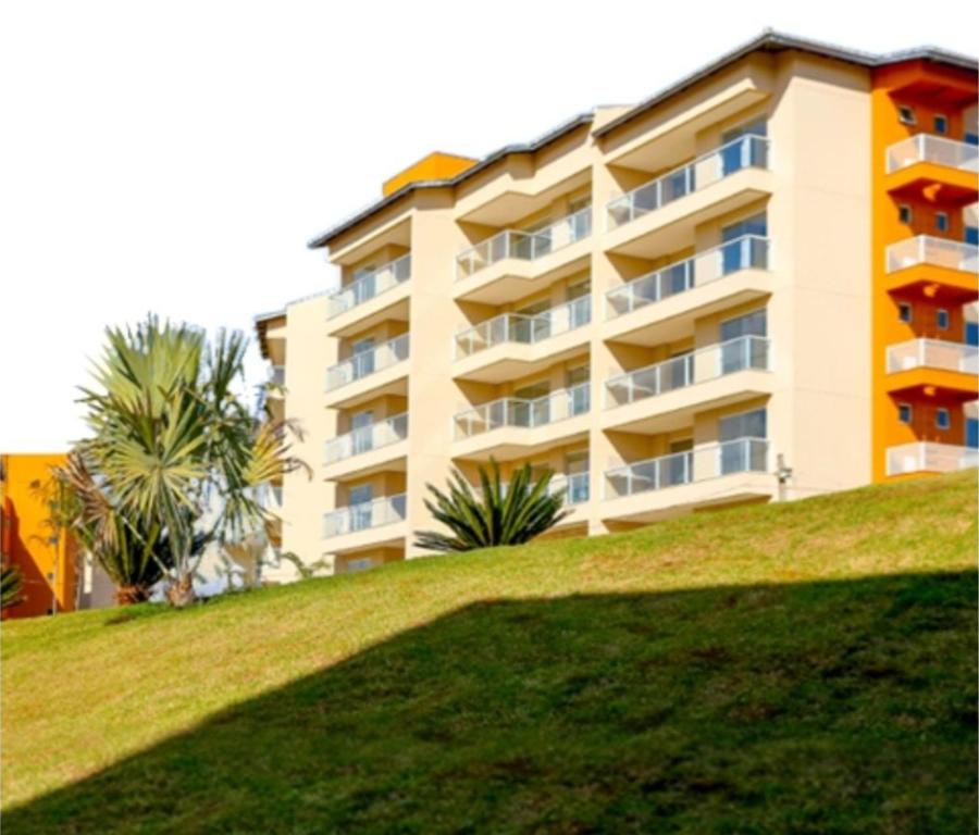 a building on a hill next to a grassy hill at Ilhas do Lago Resort in Caldas Novas