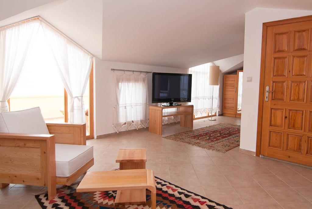 a living room with a couch and a television at Lycia Hotel in Kaş