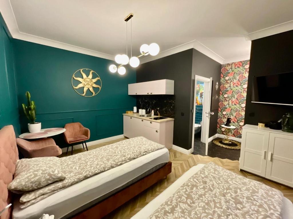 Cet appartement comprend une chambre avec un lit et une table ainsi qu'une cuisine. dans l'établissement Apartamenty Green, à Stargard