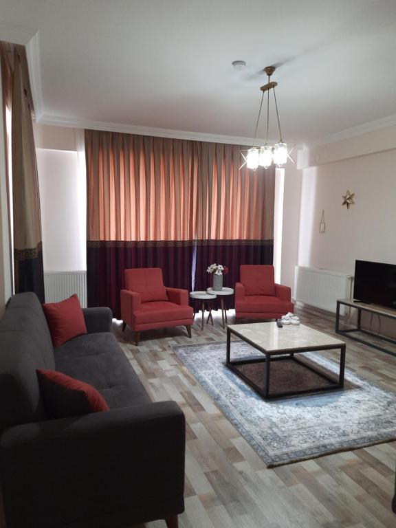 ein Wohnzimmer mit einem Sofa und zwei roten Stühlen in der Unterkunft Z&B HOME in Nevşehir
