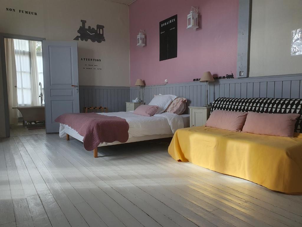 2 łóżka w pokoju z różowymi ścianami w obiekcie The Gare Gondrin w mieście Gondrin