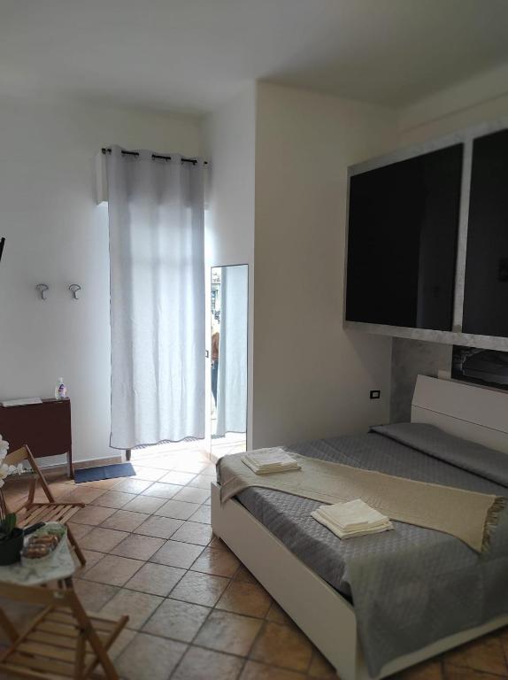 - une chambre avec un lit et une télévision à écran plat dans l'établissement Affittacamere “La spezia “, à La Spezia
