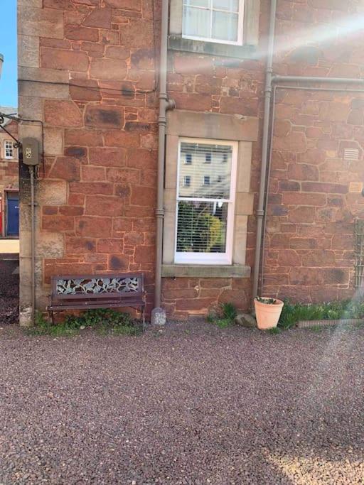 a bench sitting in front of a brick building at The Beach Pad North Berwick in North Berwick