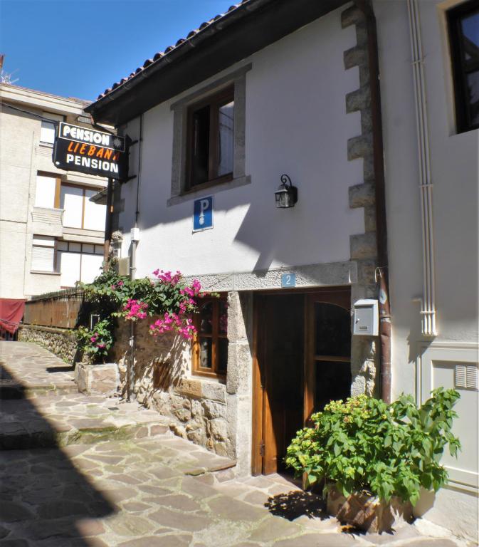 a building with a door and flowers in front of it at Pensión liebana in San Vicente de la Barquera