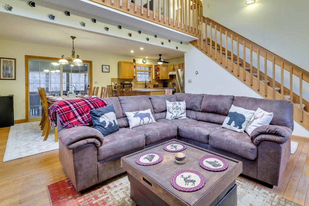 ein Wohnzimmer mit einem braunen Sofa und einem Tisch in der Unterkunft Hot Tub, Game Room! Poconos Home 22 Mi to Slopes in Gouldsboro