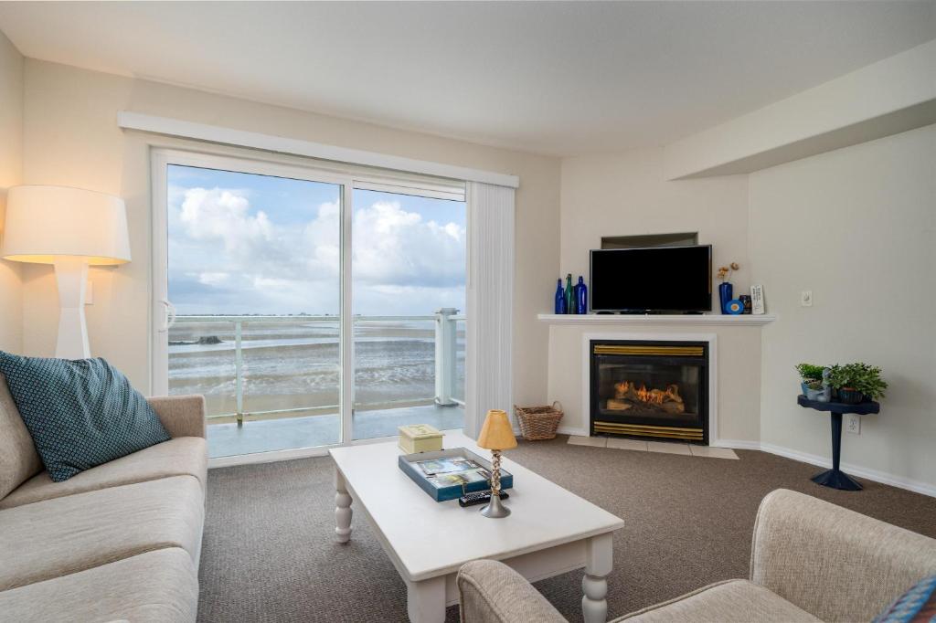 ein Wohnzimmer mit einem Kamin und Meerblick in der Unterkunft Waters Edge 410 in Lincoln City