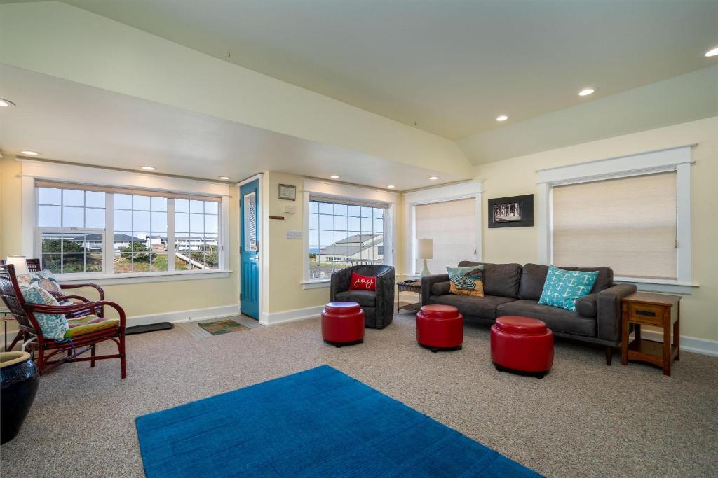 a living room with a couch and a table and chairs at Nyevana Beach House in Newport
