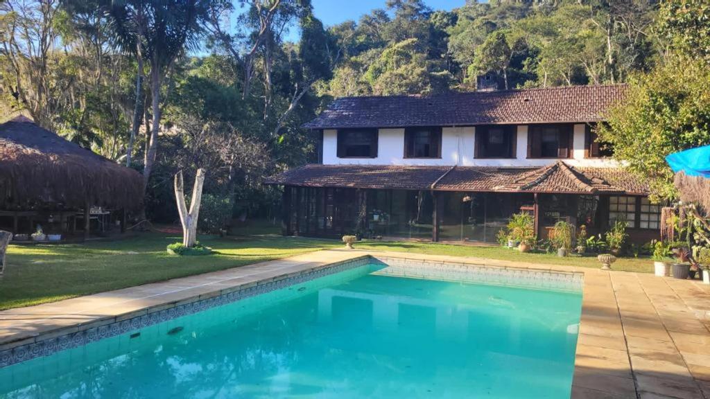 una casa con piscina frente a una casa en Kronemhouse Pousada en Petrópolis