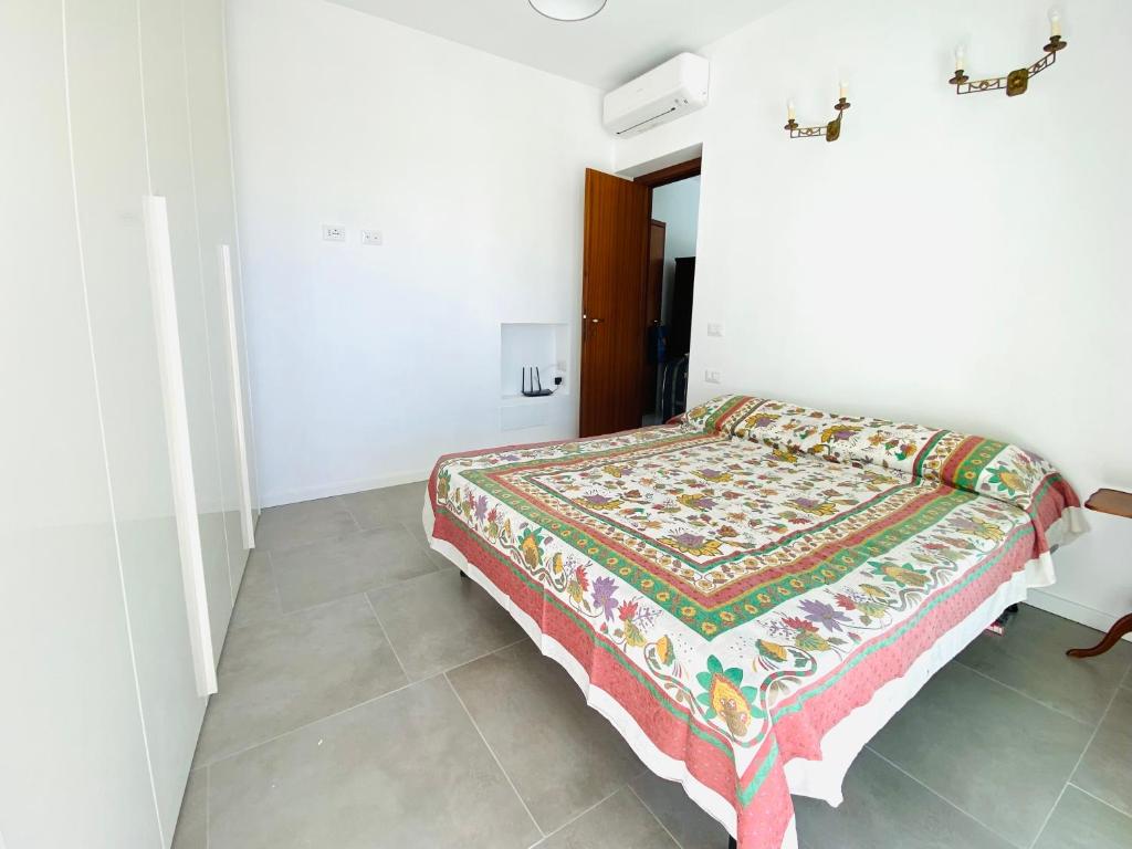 a bedroom with a bed with a colorful blanket on it at La Stella Marinella in Santa Marinella