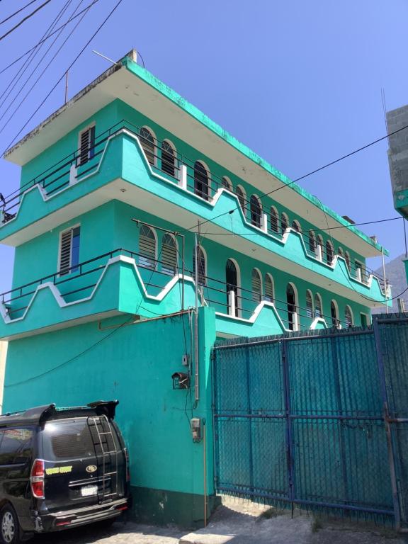 une maison bleue avec une voiture garée devant elle dans l'établissement CASA BATZ #1, à San Pedro de la Laguna