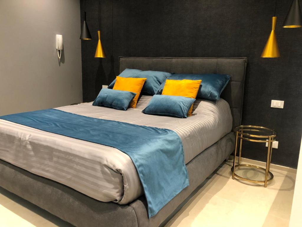 un grande letto con cuscini blu e gialli sopra di Suite Apollinare a Ravenna