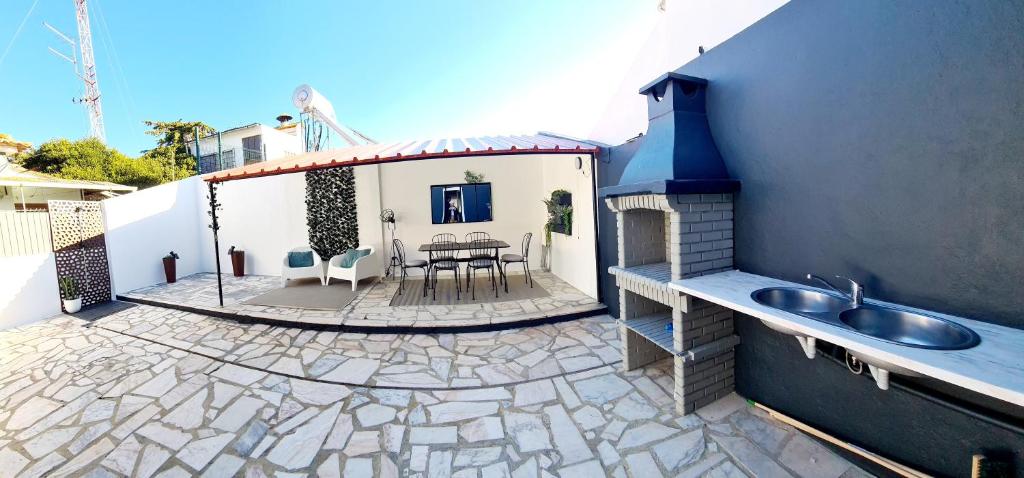 a backyard with a patio with a sink and a table at Arrábida Cozy House in Palmela