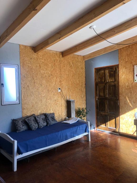 um quarto com uma cama azul num quarto em Casa de montaña em Potrerillos